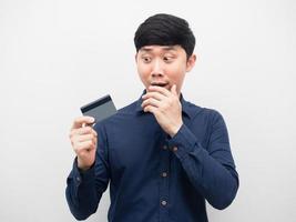 Man feeling shocked looking at credit card in hand photo
