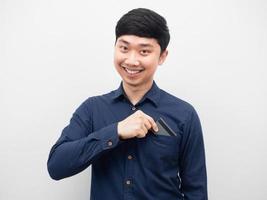 Man smiling and pick up credit card of shirt pocket photo