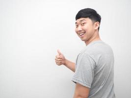 Asian man turn back for thumb up with happy smile emotion copy space photo