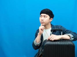 Man with luggage gesture thinking and looking at copy space holiday concept photo