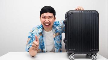 Cheerful man blue shirt thumb up with luggage vacation trip concept photo