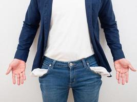 Closeup man body without money in jean pocket and empty hand on white background poor people concept photo