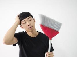 Asian man feeling bored looking at sweep in his hand on white background