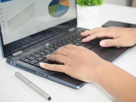 Close up hand using laptop charts graphs business at screen on the table photo