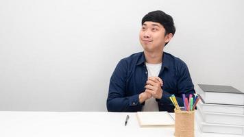 Asian man sitting at the desk happy emotion looking at copy space photo