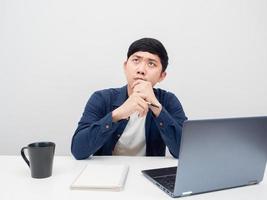 Man with his workplace thinking something and looking up,Man with laptop on the desk photo