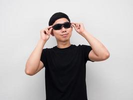 Man touch his sunglasses looking up white background photo