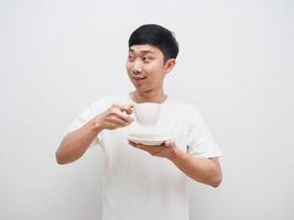 Asian man hold coffee cup in hand and look at left side with happy smile on white isolate background photo