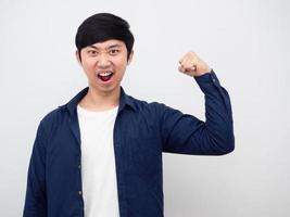 hombre asiático mostrar músculos cara alegre mirar hombre de negocios fondo blanco retrato foto