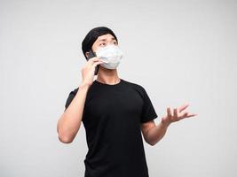 hombre asiático con máscara hablando con teléfono móvil en serio fondo blanco foto