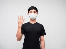 Asian man black shirt with mask show four finger counting on white isoated background photo