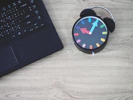 Top view laptop keypad and retro analog clock vintage style on wooden table work photo