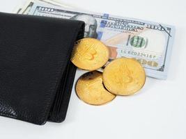 Golden bitcoins at wallet and dollar money white background photo