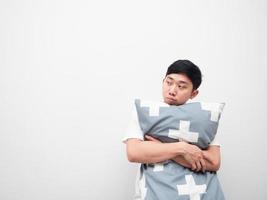 Asian man hug pillow feeling sleepy look at space white background photo