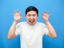 Man gesture scared at you,Asian man hand up gesture horror blue background photo