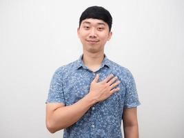 Handsome man blue shirt cheerful and touch his chest feeling hopeful photo