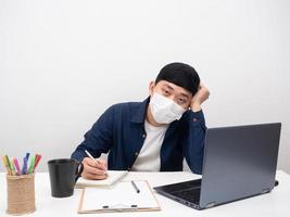 Man wearing mask fee sick sitting at workplace for working photo