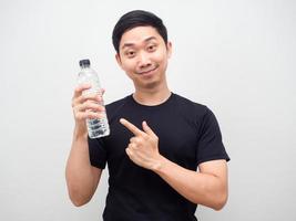 Man point finger at water bottle in his hand with happy face white background photo