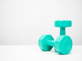 Dumbbell green color on the table white background copy space photo