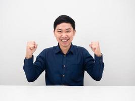 Handsome man sitting at desk gesture success show fist up feeling happy photo