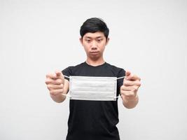 Young man black shirt looking mask protect in his hand on white isolated background quarantine concept photo