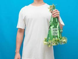 Man holding happy new year hat green color blue background photo