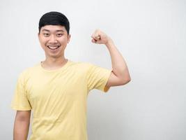 Handsome man yellow shirt smiling show muscle copy space photo