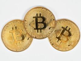 Closeup three golden bitcoins detail on white background photo