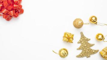 Golden christmas accessories  and red ribbon on white background top view copy space photo