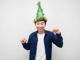 Asian man wearing green hat gesture fun dance with new year celebration concept photo