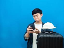 Man with luggage holiday feeling sad with money in his wallet blue background photo