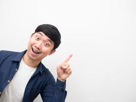 Cheerful man gesture point finger at copy space photo