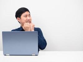 Asian man with laptop on the table feeling afraid looking at copy space white isolated photo