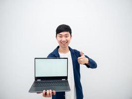 Asian cheerful man show laptop white screen in hand and thumb up looking at camera on white isolated background photo