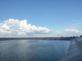 Water in reservoir landscape with cloudy and blue sky,Dam on the mountain and wind generator beautiful view photo