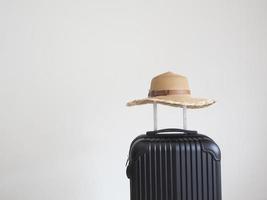 Vintage hat above luggage black color on white isolated space photo