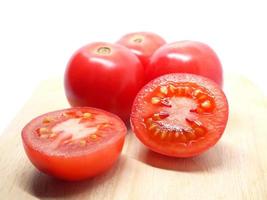 Primer plano detalle frescura tomate ciruela rebanada cortada en una tabla de cortar naturaleza luz sombra sobre blanco aislado foto
