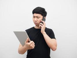 Man talking with mobile phone and looking at tablet about work photo