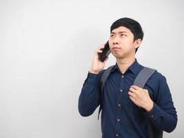 Man with backpack talking with mobile phone looking at copy space photo