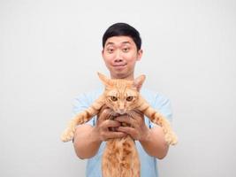 Young man showing domestic cat orange color in his hand white background photo