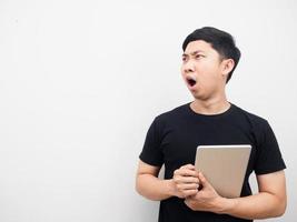 Man holding tablet feeling shocked looking at copy space photo