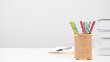 Pencil box pen books on the table copy space white background photo