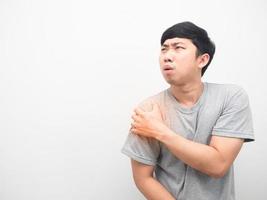 Asian man gesture hurt his shoulder looking at copy space photo