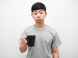 el hombre que sostiene la taza de café se siente somnoliento, el hombre sin dormir círculo oscuro debajo de los ojos foto