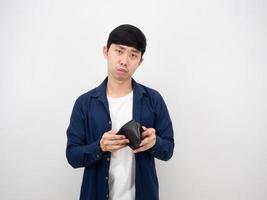joven asiático cara triste sobre la billetera en la mano mirando a la cámara sobre fondo blanco aislado concepto pobre