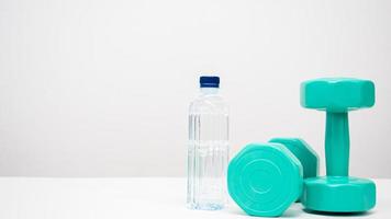 Dumbbell with water bottle on the table white background copy space photo