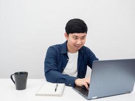 hombre asiático que usa una computadora portátil para trabajar en la mesa foto
