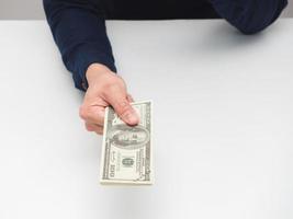 Man hand giving money dollar on the table,Earn salary concept