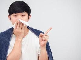 Sick man asian close his nose by tissue point finger at space white background photo