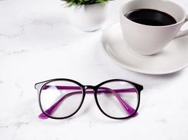 Closeup glasses coffee cup with flower vase on the marble table background copy space morning photo